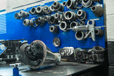 Toyota third member with ring and pinion gear set on bench, differential housings on pegboard at Tru Automotive Denver